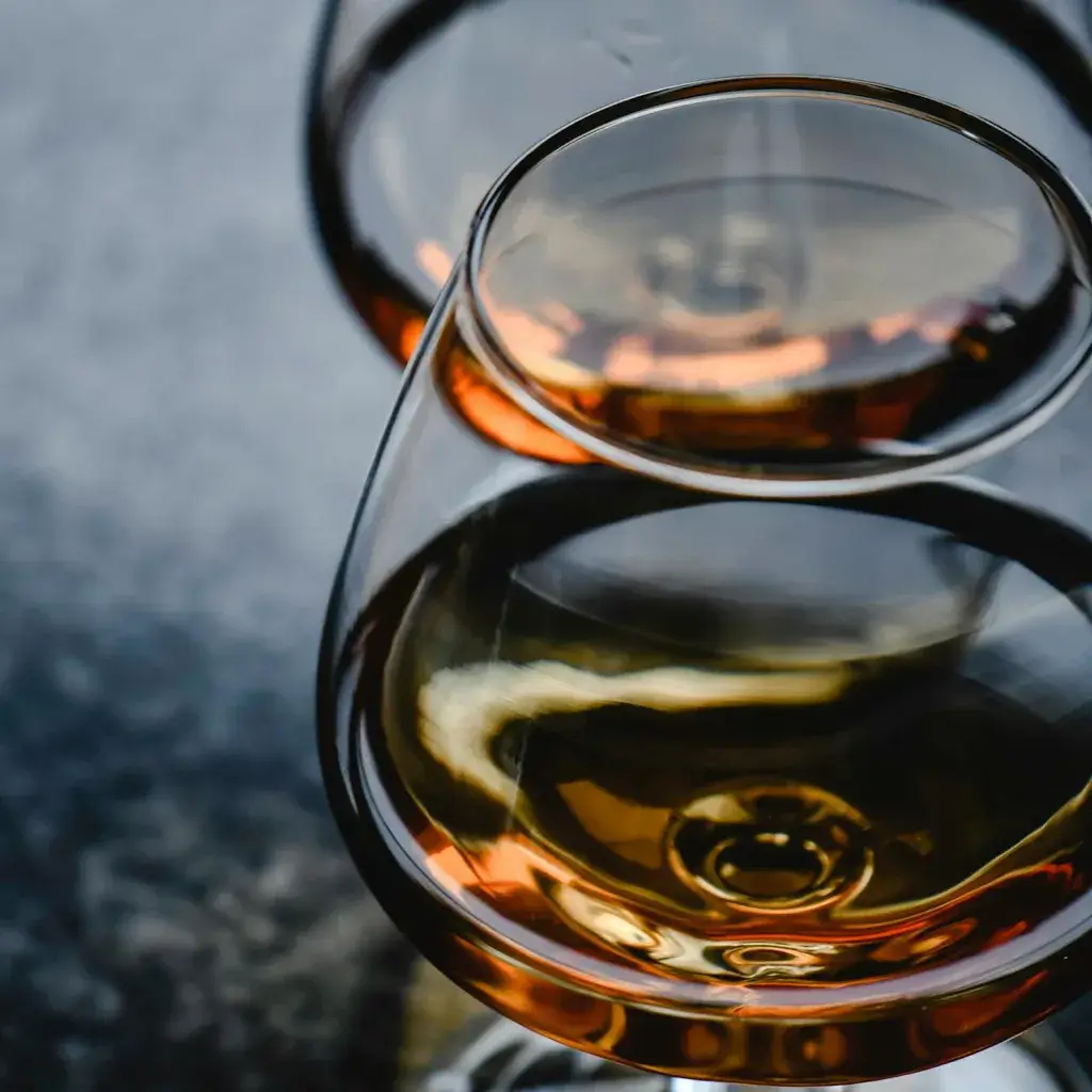 Elegant whisky glass with amber whisky in moody bar lighting