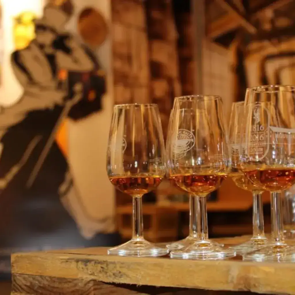 Nosing glasses with whisky on rustic wood in a warm distillery setting
