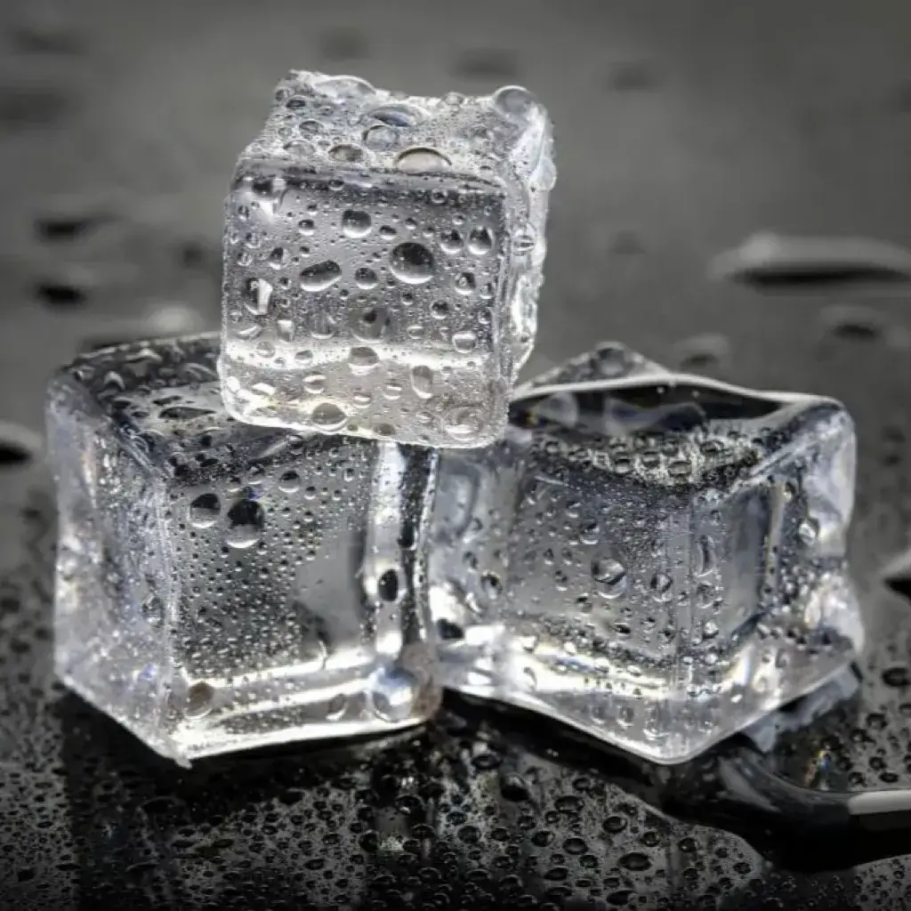 Ice cubes with condensation on a dark surface